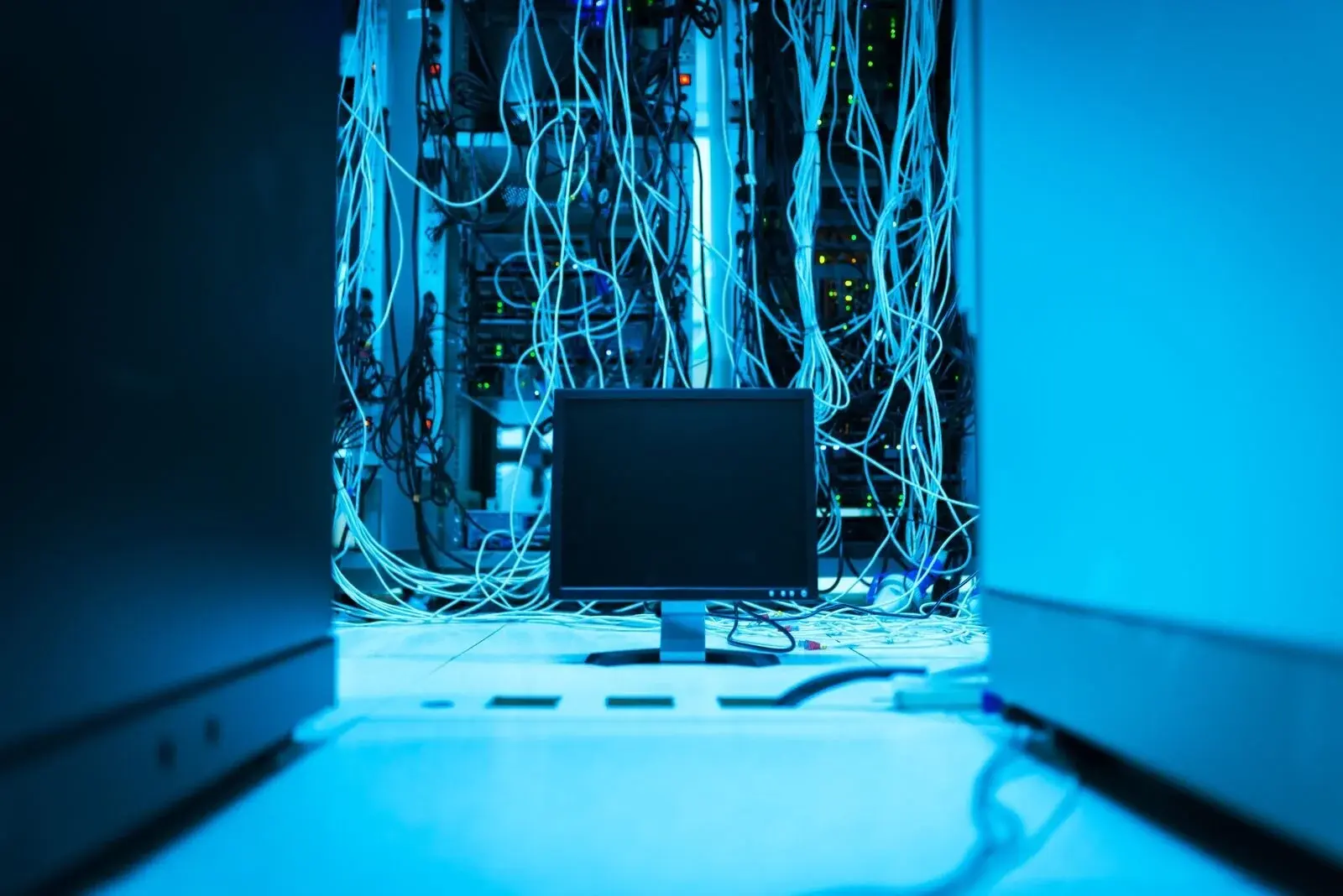 Server rack with a tangle of cables and a screen, illustrating a technical stack that has become difficult to read