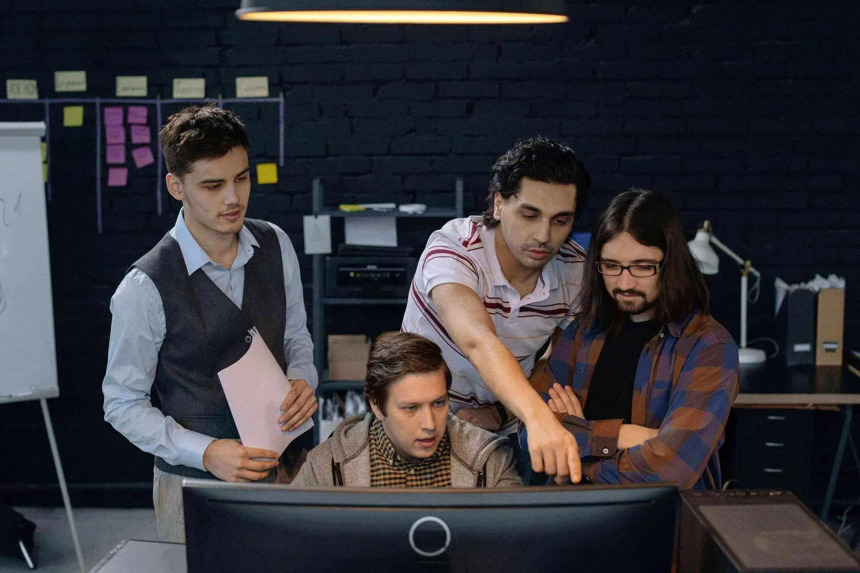 Team gathered around a screen to examine a work process